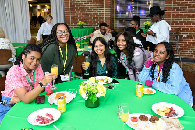 A group of women sit at a table for the DEI brunch during Homecoming 2022.