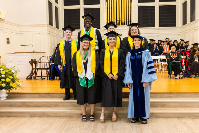 students in regalia pose