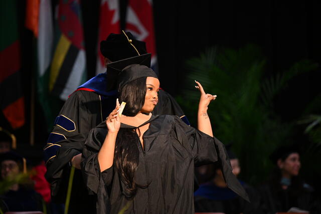 student in regalia at graduation ceremony
