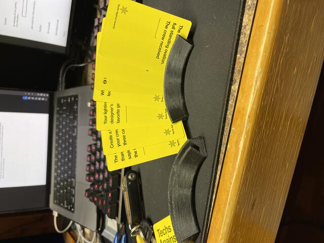 Photo of a 3D printed cardholder with a set of yellow cards standing in it.