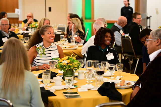 Group of people sit at a round table at a formal event