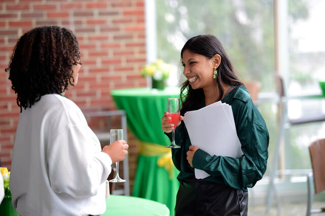An alum enjoying a chat with a classmate. 