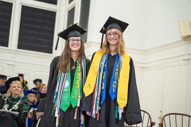 2 students in graduation regalia
