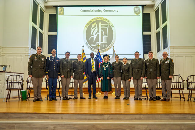 Group photo of cadets and military science faculty with President Julia Jasken on stage at Commissioning.