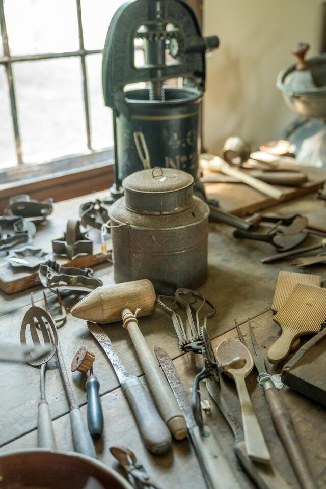 An array of metal and wooden kitchen utensils on a table.