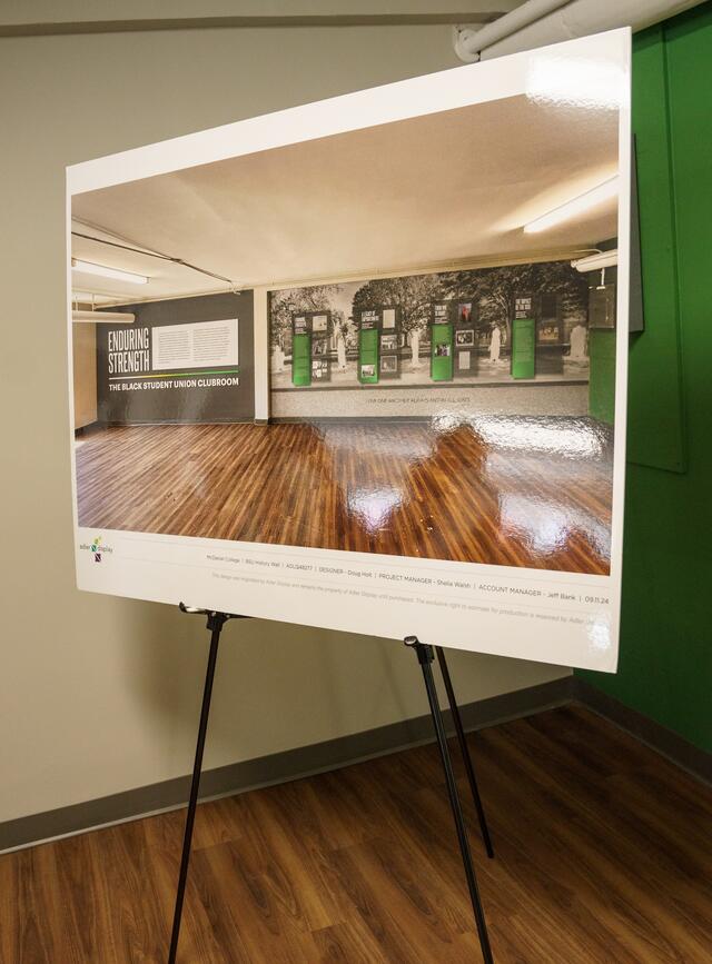 Image or a large sign on a tripod featuring an image of the wall of the BSU clubroom and the words Enduring Strength