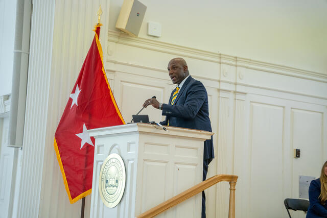James Martin in a blue suit standing at a podium.