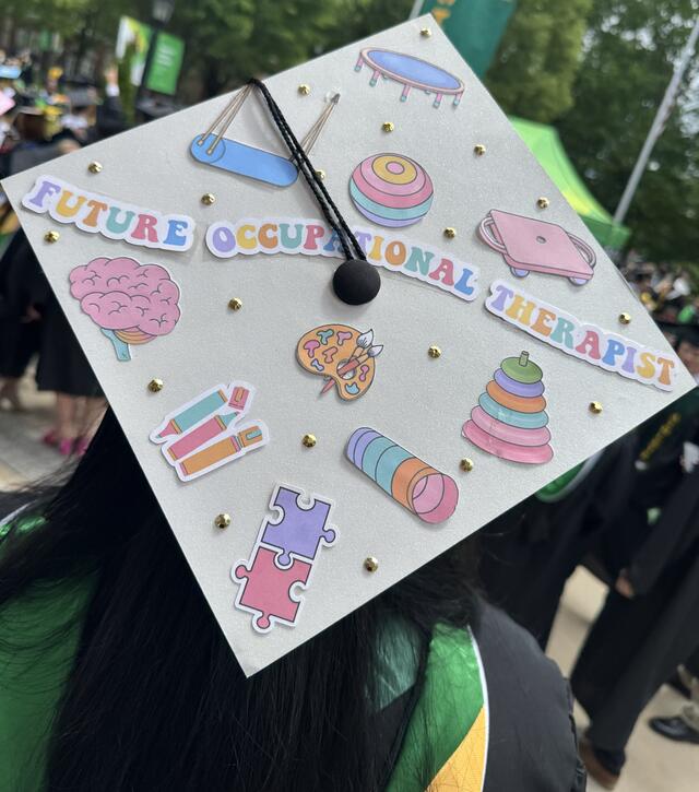 A graduation cap decorated with images of assistive tools and the phrase "Future Occupational Therapist."