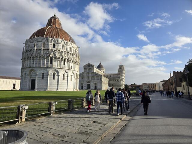 A white cathedral in the distance with students walking next to it.
