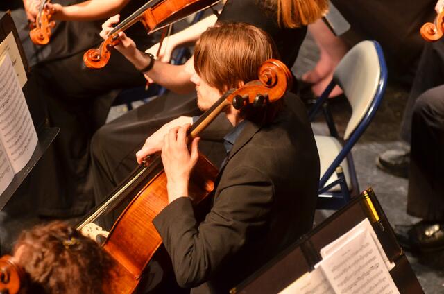 student plays an instrument in an orchestra
