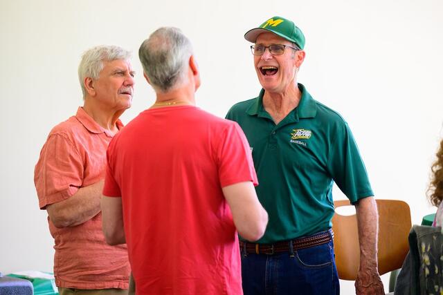 Alums laugh with each other.