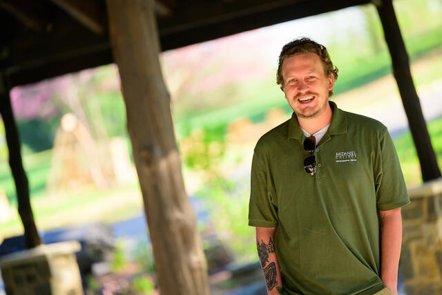 A student shares a laugh with alumni while presenting at the new Harvey Stone.