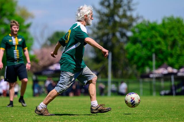 An alum charges up the pitch at the Men's Soccer alumni game.
