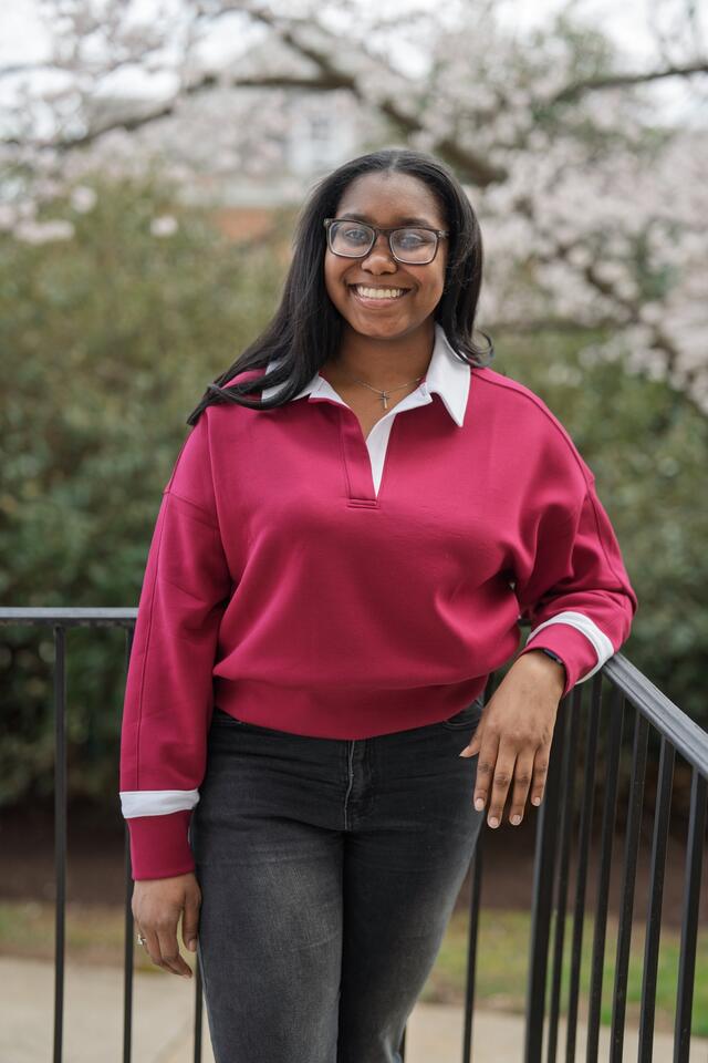A female student wearing glasses smiles on the McDaniel campus.