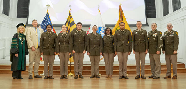 Seven cadets stand with McDaniel military leaders and President Julia Jasken.
