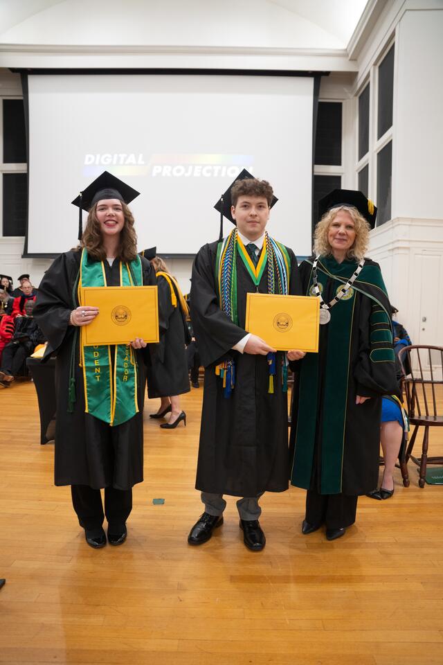 Students in graduation regalia pose with President Julia Jasken, also in graduation regalia