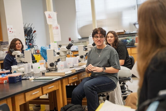 Students sit and talk in a lab.