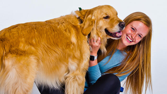Morgan Collinson, petting a golden retriever