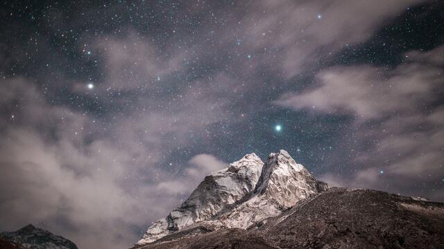 Clouds and stars over a mountain