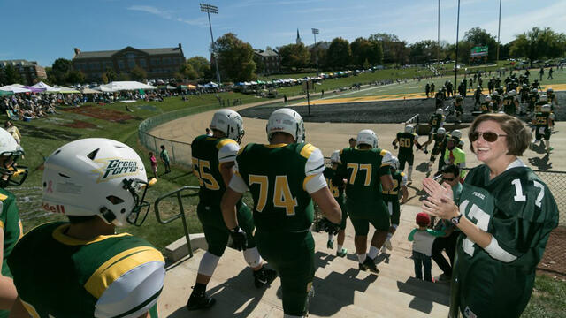 Football players walking down the steps to the field.