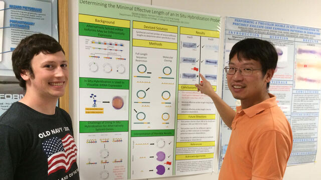 Senior Garrett Gregoire discusses his research with Biology professor Cheng Huang.