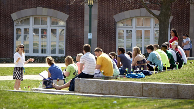 Professor lecturing class outdoors.