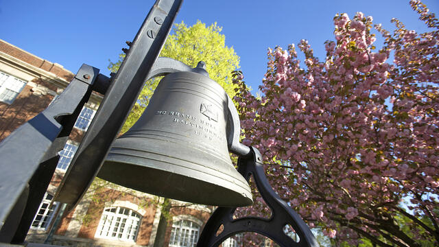 Bell in front of campus in spring
