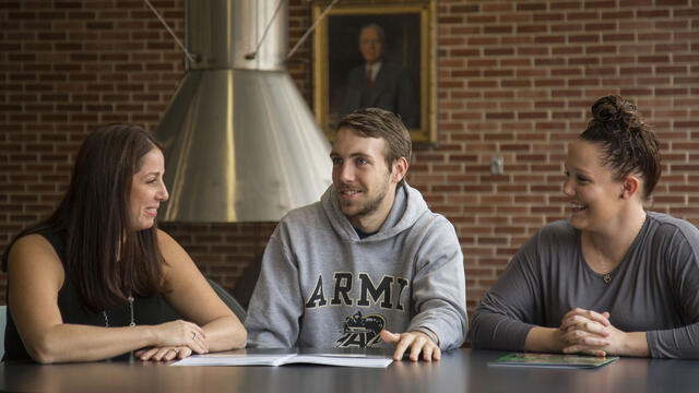 Students in conversation sitting at table.