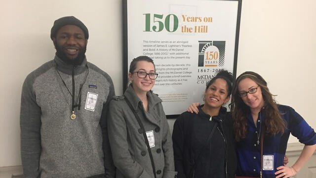 Social Work majors standing in front of poster.