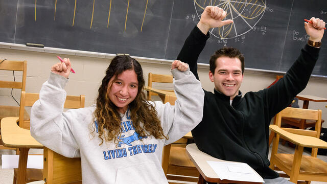 Estimathon Kathalyn Urquizo and Dimitri Lezcano raising their arms in celebration.