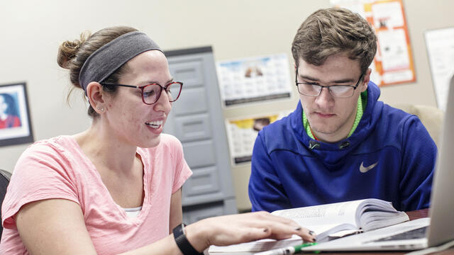 Graduate assistant working with student.