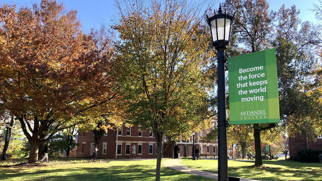 McDaniel College campus in Fall with Keep the World Moving banner