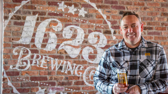 Mike McKelvin in front of the sign for 1623 Brewing.