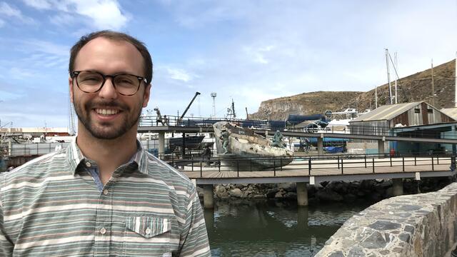 Alum Jason Swartz '18 standing at a marina.