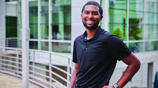 Alumni Kevin Webster posing on campus.