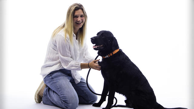 Bethany Rippon poses while kneeling with a dog.