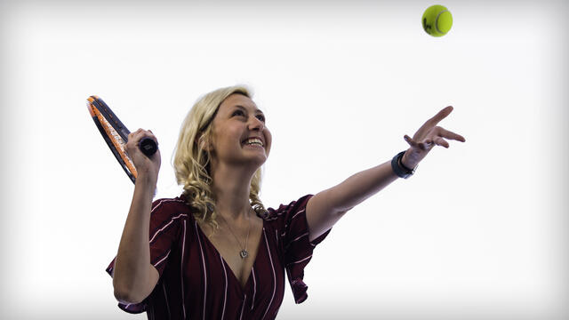 Kassidee Wright prepares to hit a tennis ball she has tossed into the air.