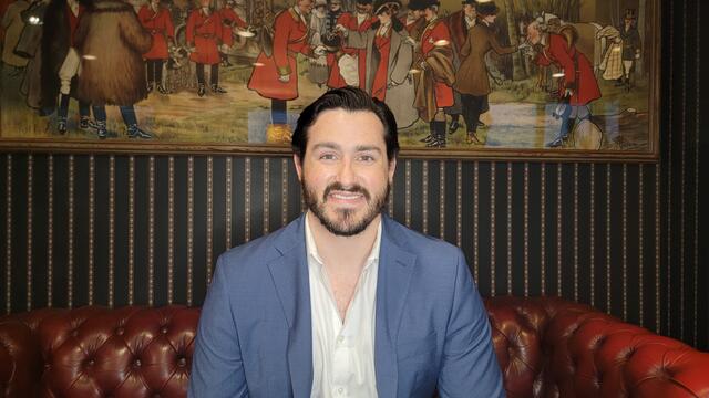 Photo of alumni Diego Weiner sitting on a couch.