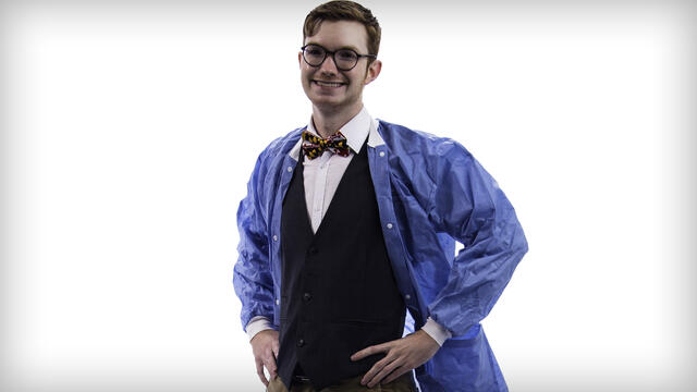 Zach Drechsler posing in a lab coat with hands on hips.