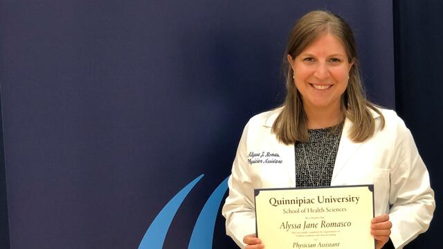 Photo of alumna Alyssa Romasco holding her degree from Quinnipiac University.