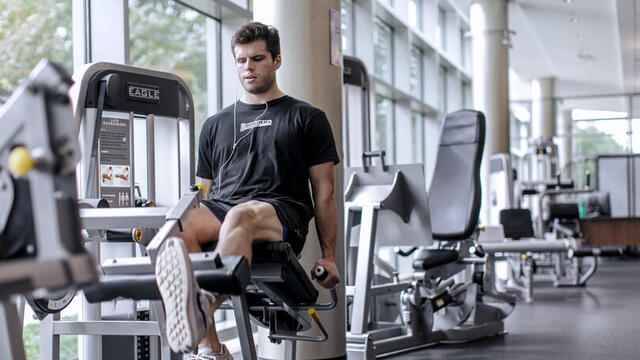 Photo of a student using a weightlifting machine in Merritt Fitness Center.