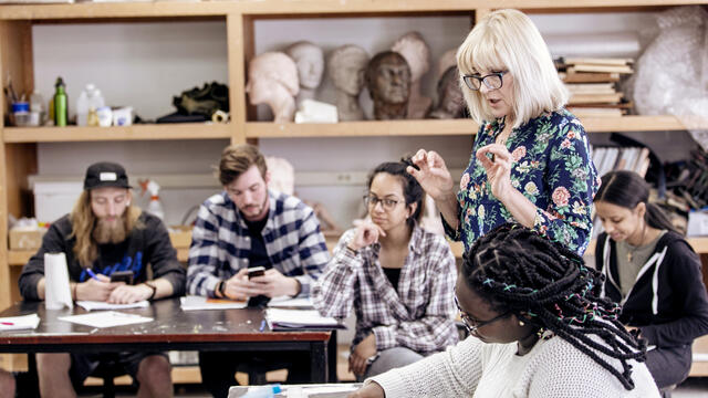 Photo of professor Katya Dovgan speaking with students in the Art Studio.