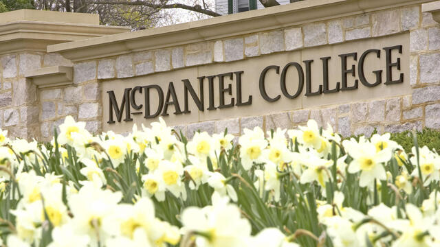 McDaniel College sign with flowers.