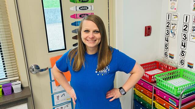 Elizabeth Bittings Seay poses for a picture in front of a door in a classroom