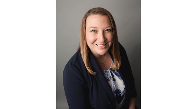 Headshot of Kristi Yowell in a black suit jacket.