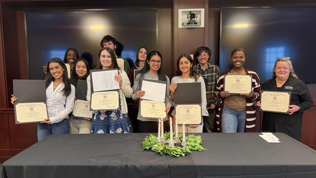 Students standing in a group holding their induction certificates 