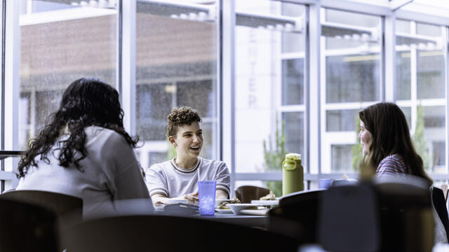 A group of students sitting and chatting in Ensor Lounge. 