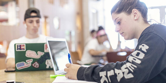 Students with notebooks and computers.