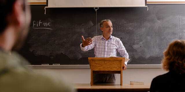 Professor lecturing in front of class.