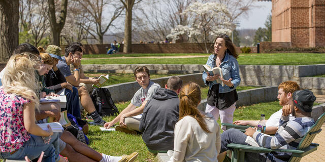 Professor lecturing class outdoors.